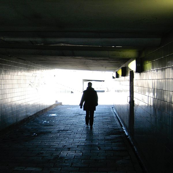 En människa går genom en mörk tunnel.