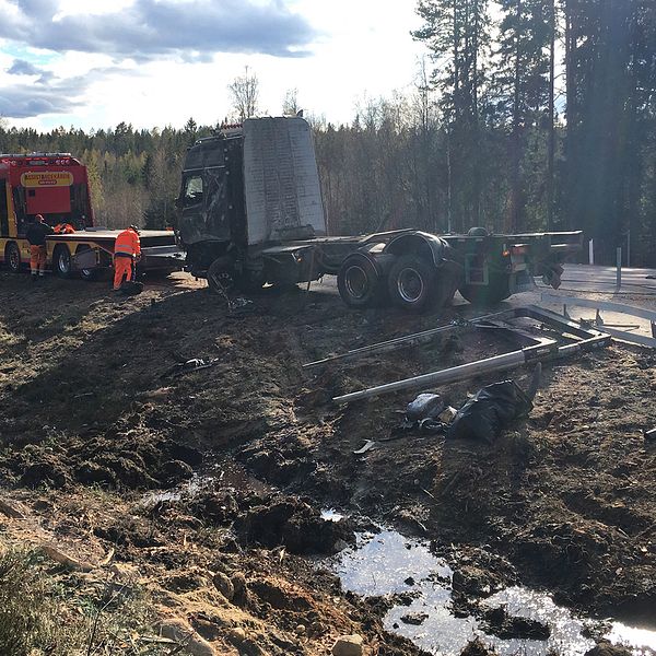 bärgningsbil och lastbil samt personal, lerigt dike i förgrund
