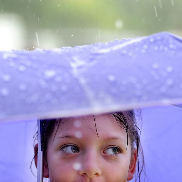 Flicka under paraply.