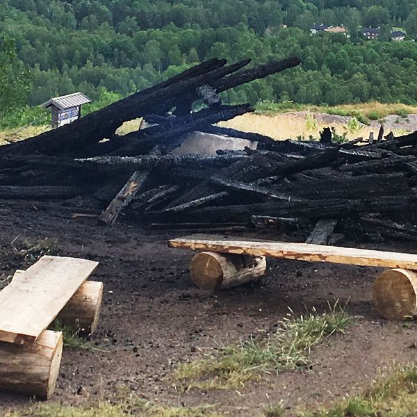 En hög svartbränt virke. Svag rök stiger från resterna efter konstverket ”Waaall”.