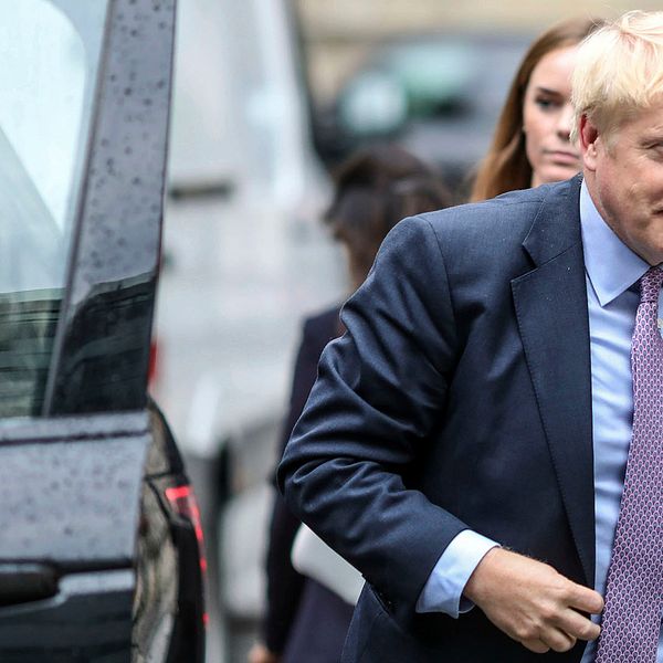 Boris Johnson kliver ut en bil.