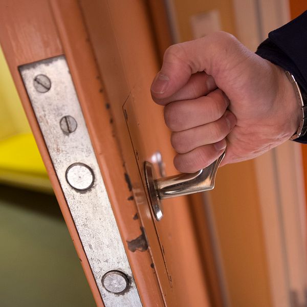 Arrestlokal polisman öppnar dörr till arrest på polisstation