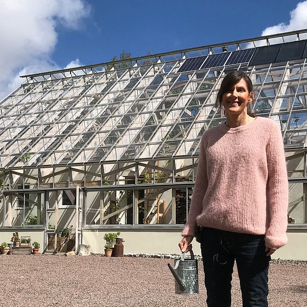 Susanne Andersson framför sitt hus i Havredal. På taket syns solpanelerna och solcellerna.