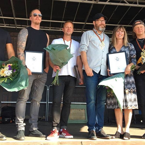 Bild på de som blivit invalda i Jämtland Pop Music Hall of fame 2019. Från vänster Aeon, Morgan Hall, Landstrom och 220 Volt. De står på scen med priser, plaketter och blommor.