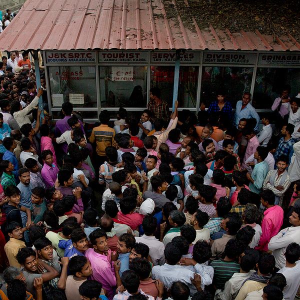 Indiska arbetare trängs utanför det statliga biljettkontoret för att ta sig ur regionen efter utegångsförbudet i Kashmirs största stad Srinagar under onsdagen.