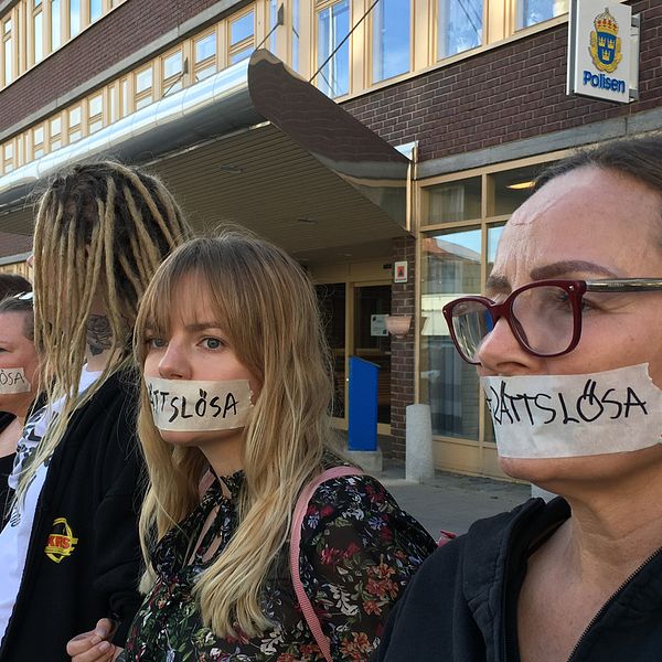 Kvinnor framför polishuset med tape för munnen. På tapen står det ”rättslösa”.