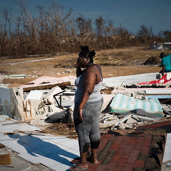En kvinna tittar ut över sin söndertrasade fastighet i High Rock på ön Grand Bahama.