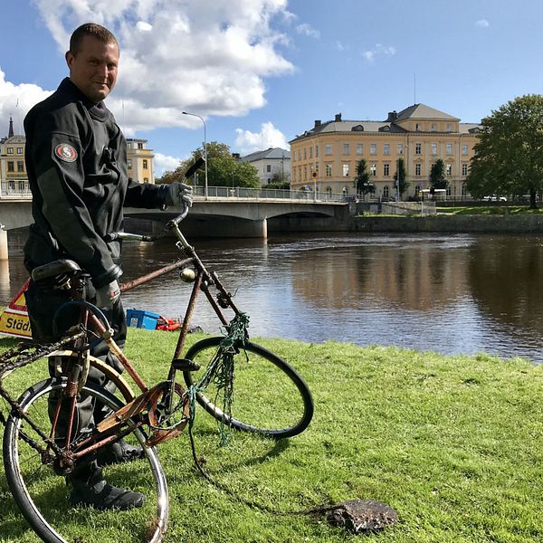 Krisofer Johannesson i Karlstads Dykarklubb står med en cykel som plockats upp ur Klarälven