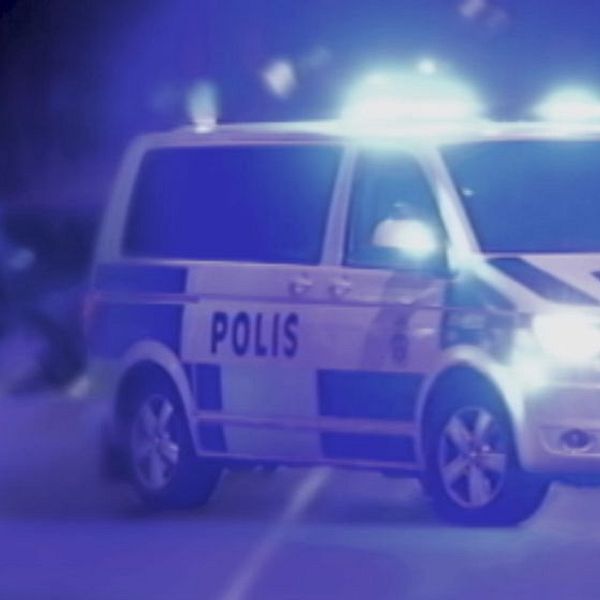 polisens piket-bil på gatan med blåljus på, suddiga figurer