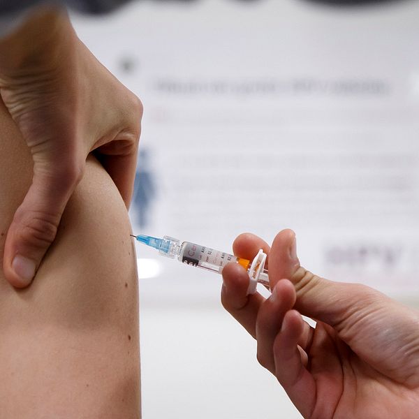 En kvinna som får en spruta med HPV-vaccin.