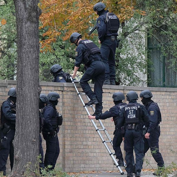 Poliser klättrar över en mur nära platsen för skjutningen i Halle.