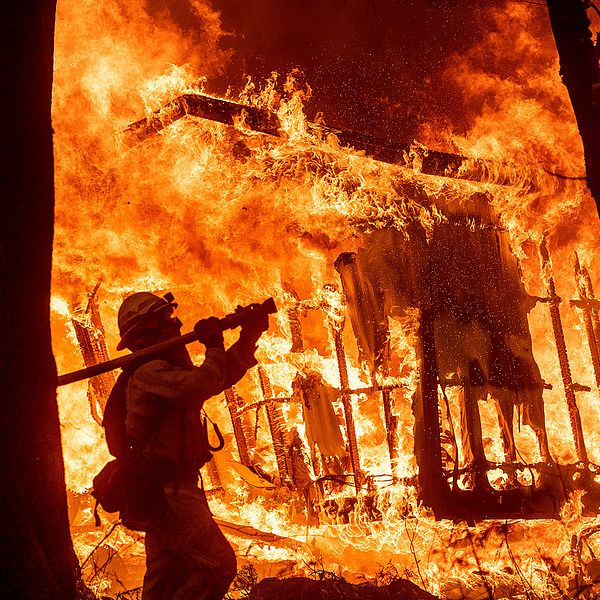 Brandmannen Jose Corona bekämpar elden som slukar ett hem i Magalia, Kalifornien.