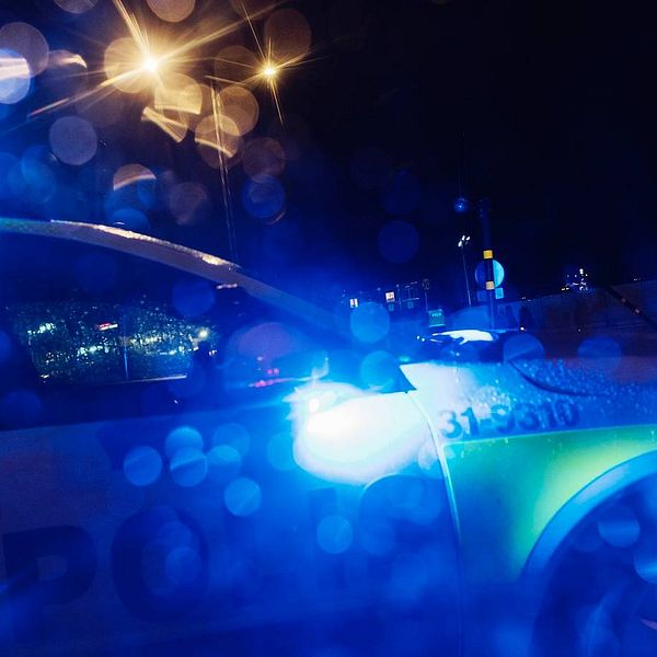 Polisbil med blåljus i mörker