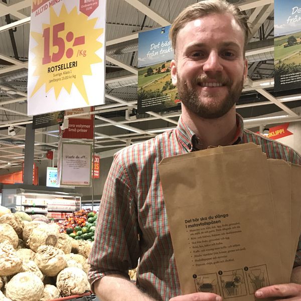 Joel Lundholm, avldeningschef över frukt och grönt i en Ica maxi-butik håller upp matavfallspåsar.