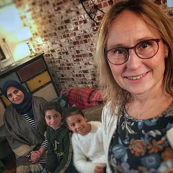 Manal Fadel med barnen Maya och Aya sitter i sin soffa i lägenheten hemma hos Tina Björn-Rasmussens hus.