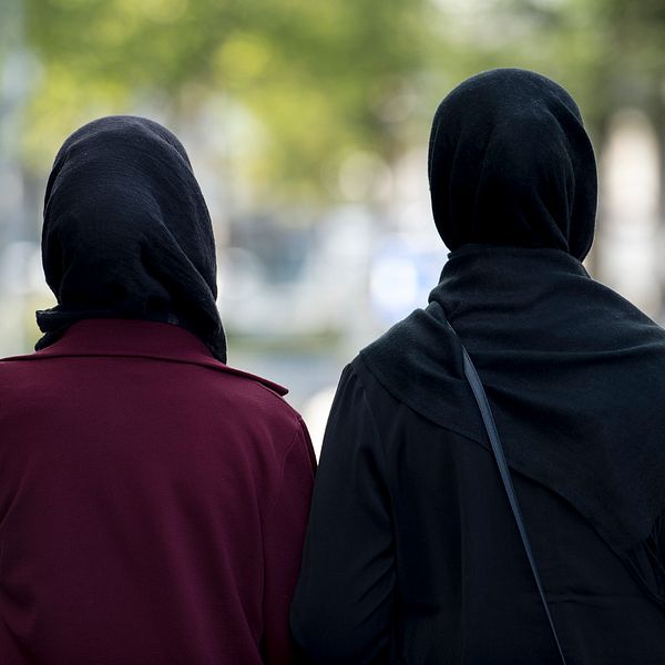 Två kvinnor i hijab fotograferade bakifrån.