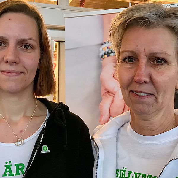 Två kvinnor, mor och dotter, står i entren till en butik i Mönsterås och tittar in i kameran.