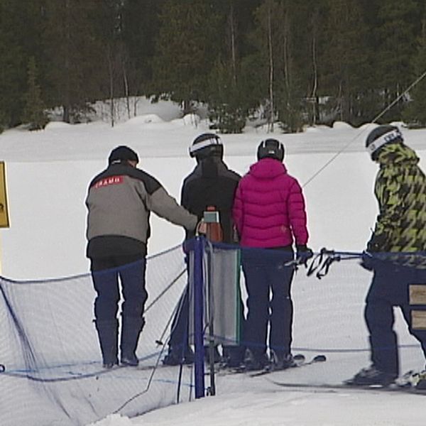 en liftgubbe hjälper skidåkare ta ankarlift