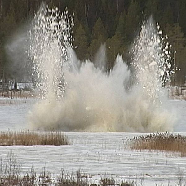 Bilden visar en explosion på Dagsådalens skjutfält där snö yr eftersom det är vinter.