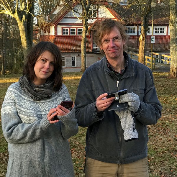 Therese Pohl och Mikael Lundgren med mobiltelefoner i kurortsparken i Lundsbrunn
