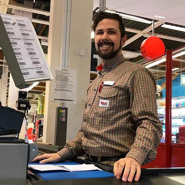Porträttbild i form av halvbild tagen på Jens Selahn på Ica Maxi Hudiksvall som står bakom en kassa.