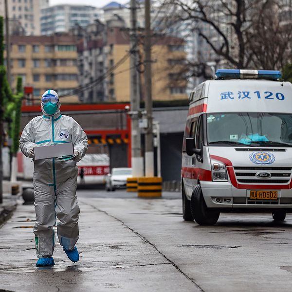 En skyddsklädd ambulansförare utanför sjukhuset i Wuhan, ett av de områden där flest fall av coronaviruset rapporterats