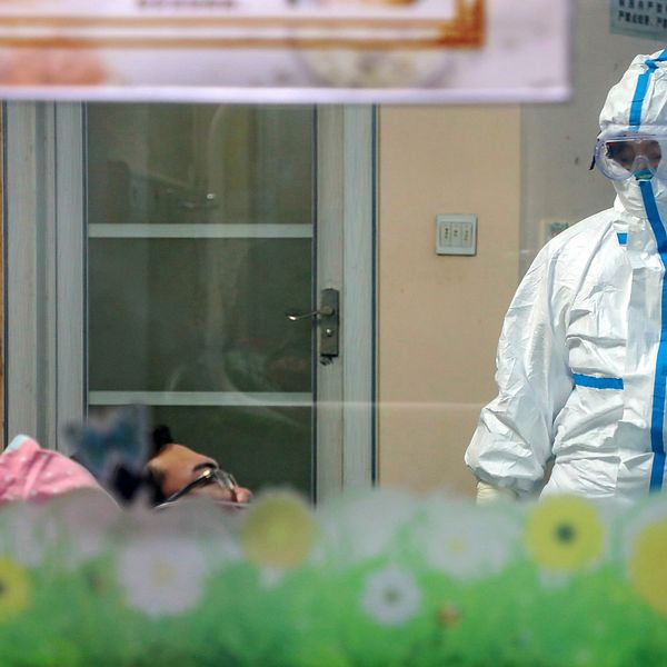 En läkare undersöker en patient i ett isoleringsrum ett sjukhus i Wuhan.