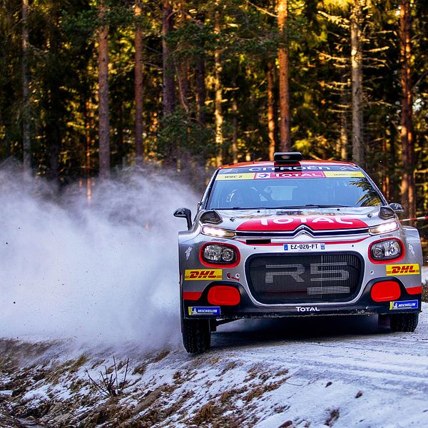 Mads Östberg i en Citroën kör i en kurva så att snön sprutar.