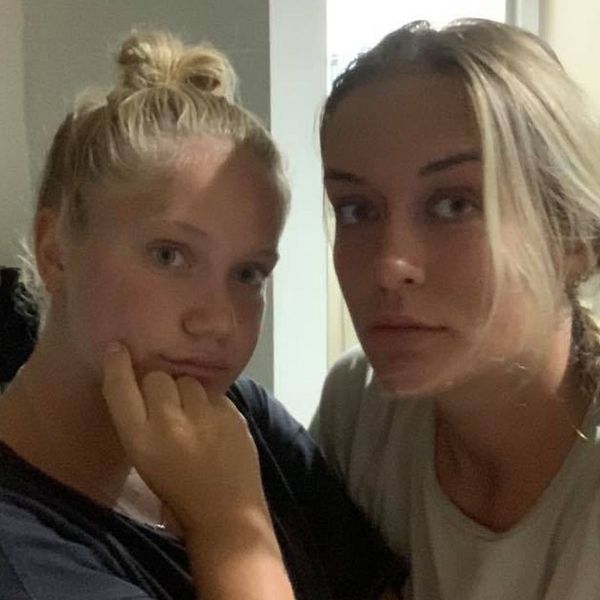 Närbild på två blonda tjejer i sitt hotellrum.
