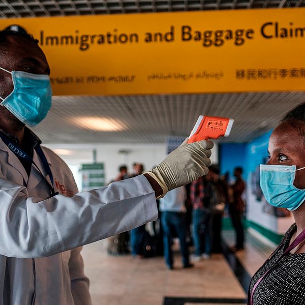 En arbetare från den etiopiska hälsomyndigheten tar tempen på en arbetare på den internationella flygplatsen i huvudstaden Addis Ababa.