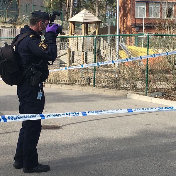 En polis fotograferar platsen där en tolvårig pojke mördades.