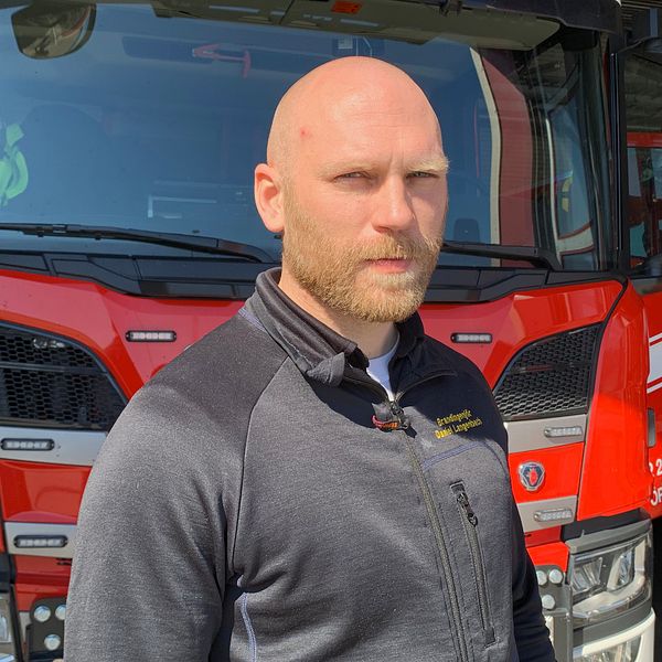 Daniel Langenback som var räddningsledare under insatsen i Zinkgruvan i Askersund står framför en brandbil.