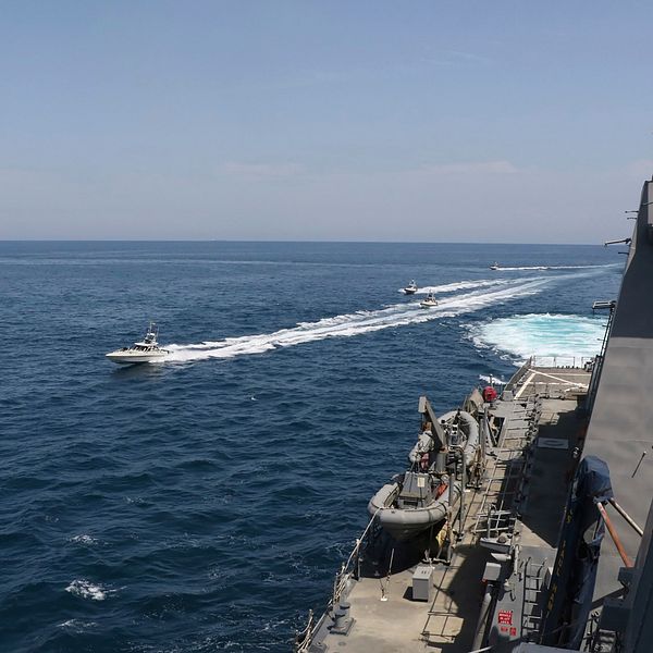 Båtar, tillhörandes det iranska revolutionsgardet, patrullerar nära amerikanska militärfartyg nära Kuwait den 15 april.