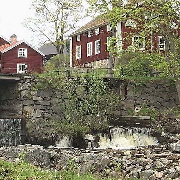 Kvarndamm, forsande vatten, röda hus.