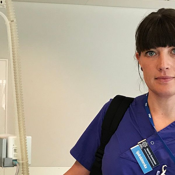Sjuksköterskan Mariette Gunnarsson iklädd blå arbetskläder står bredvid sjukvårdsutrustning.