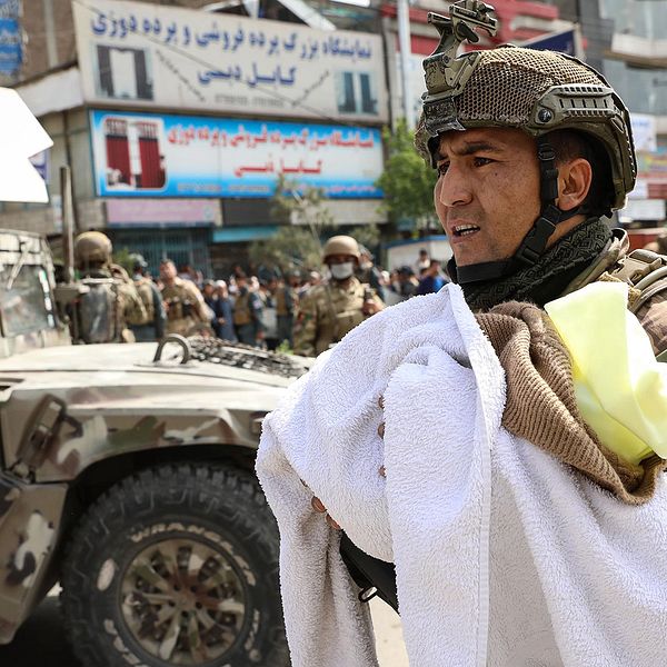En afghansk soldat bär bort ett skadat spädbarn efter attcken mot ett sjukhus i Kabul.
