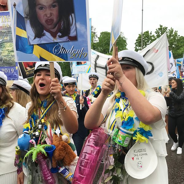 Studenter paraderar på stan bärandes på plakat.