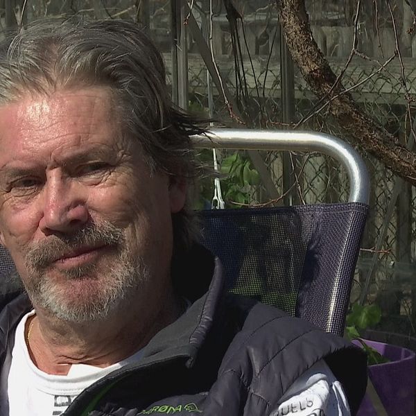 Rolf Andersson sitter på en stol utomhus med grenar i bakgrunden.