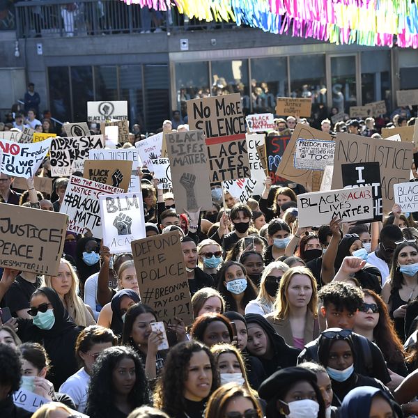 Deltagare med skyltar vid en tyst protest på Plattan, Sergels torg, i Stockholm City för att visa stöd för Black lives matter.