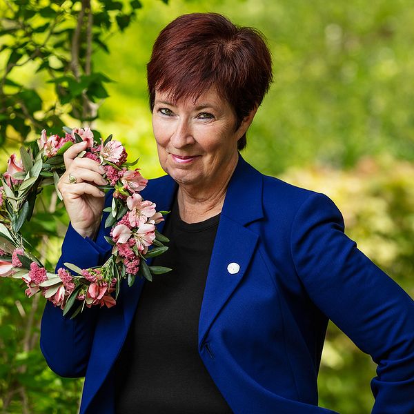 Mona Sahlin är tisdagens sommarvärld i Sommar i P1 på Sveriges Radio. Här står hon i sommargrönska och håller en blomsterkrans.