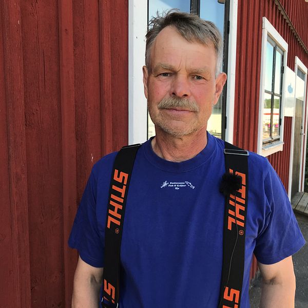 Rolf Gustafsson, fiskare, framför fiskebodar i Hjo