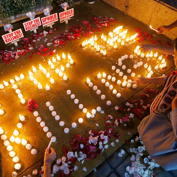 Tända ljud på marken bildar orden ”Stop the killings”. Arkivbild