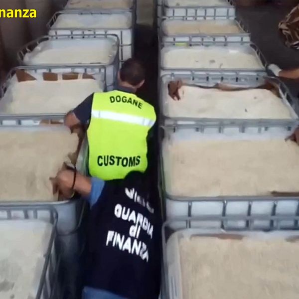 Bilder från polisen i Neapel när personal undersöker stora tråg med tabletter märkta med symbolen för captagon.