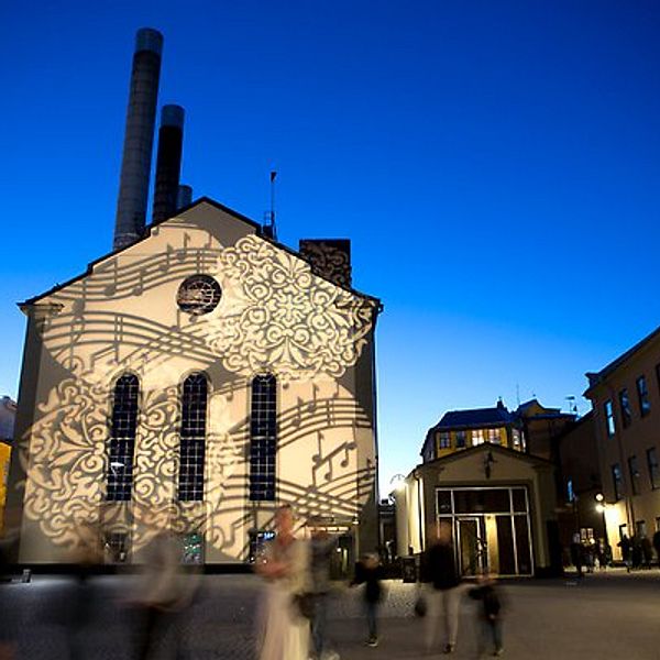 Värmekyrkan i Norrköping under Kulturnatten med ljusspel av ornament och noter.