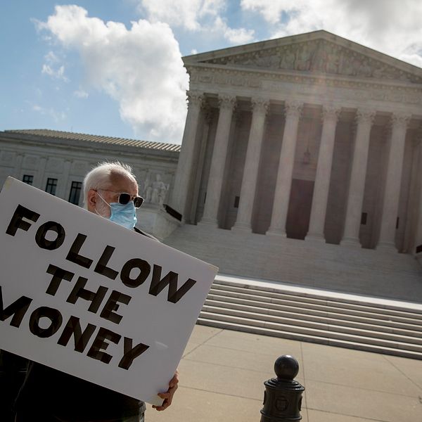 ”Följ pengarna.” En man vakade på torsdagen utanför HD i Washington DC.
