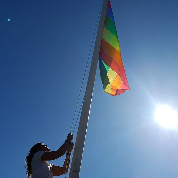 Janette Jardefalk, d på Nykvarnsbostäder hissar upp prideflagga.
