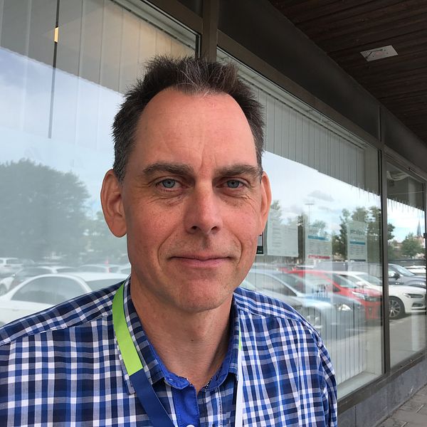 Erik Andersson i rutig skjorta står utanför Arbetsförmedlingens kontor i Katrineholm.