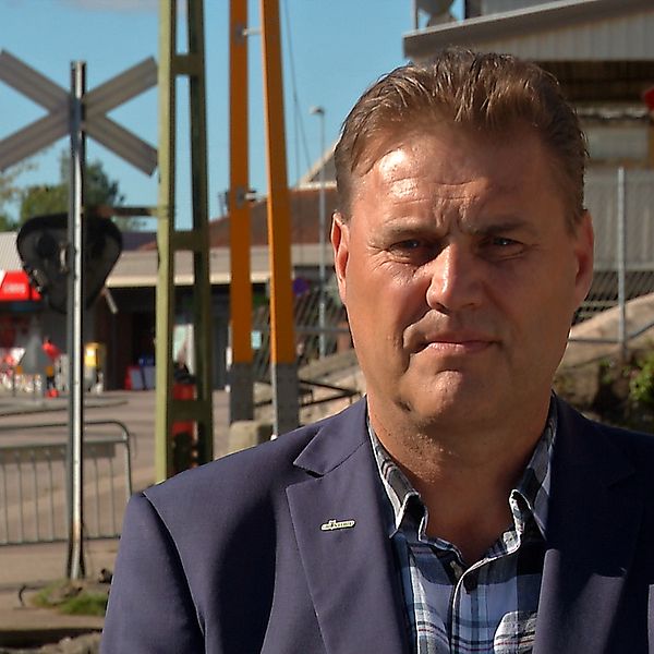 Kent Larsson, moderat kommunalråd i Grästorp, framför avstängd järnvägskorsning