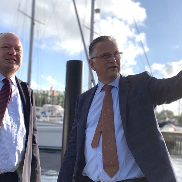 Torkild Strandberg (L) och stadsdirektör Christian Alexandersson vid hamn i Landskrona och Christian Alexandersson pekar ut förbi kameran.