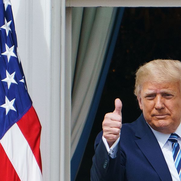 Donald Trump ger tummen upp från balkongen på Vita huset under sitt framträdande under lördagen.